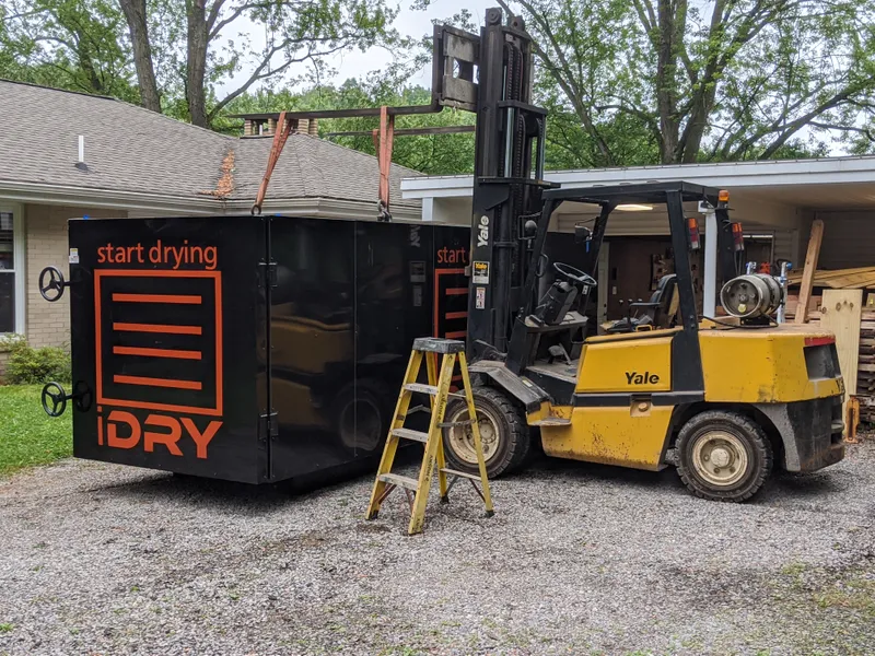 The iDry vacuum kiln being lifted into place by forklift